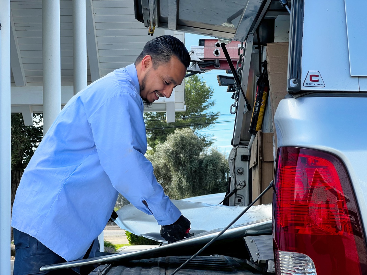 Certified HVAC tech repairing broken air conditioner in Fresno home